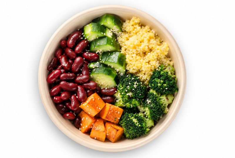Bowl mit Kidneybohnen, Couscous, Brokkoli, Süßkartoffelwürfeln und grünem Gemüse
