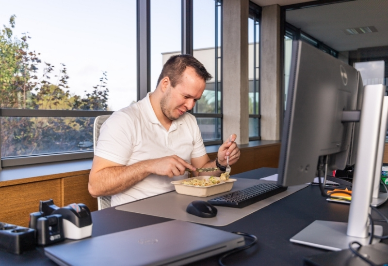 Mitarbeiter isst am Arbeitsplatz