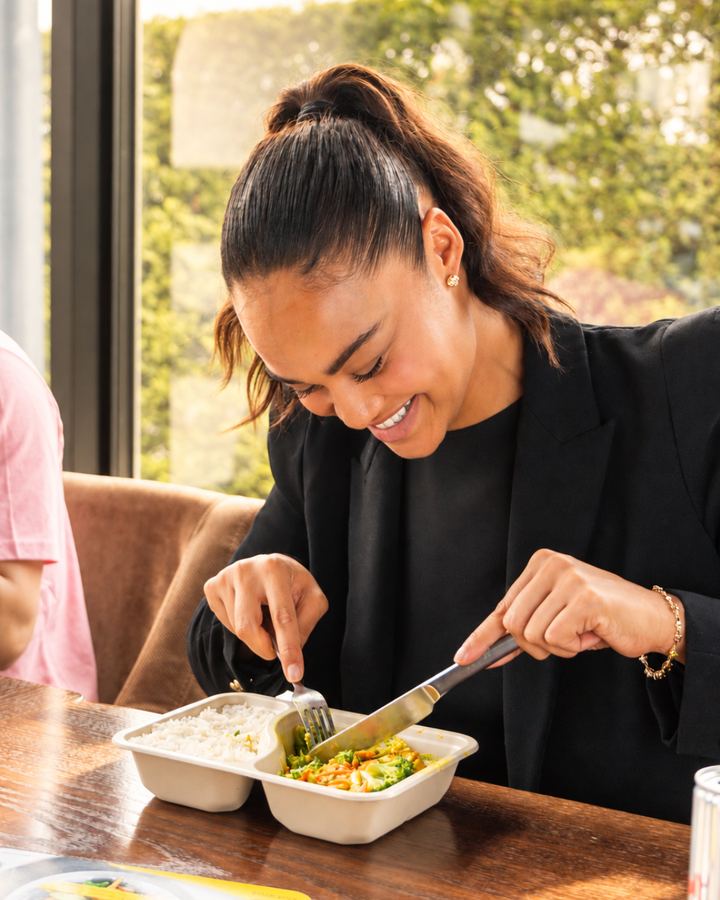 Mitarbeiterin genießt ihr Mittagessen am Tisch
