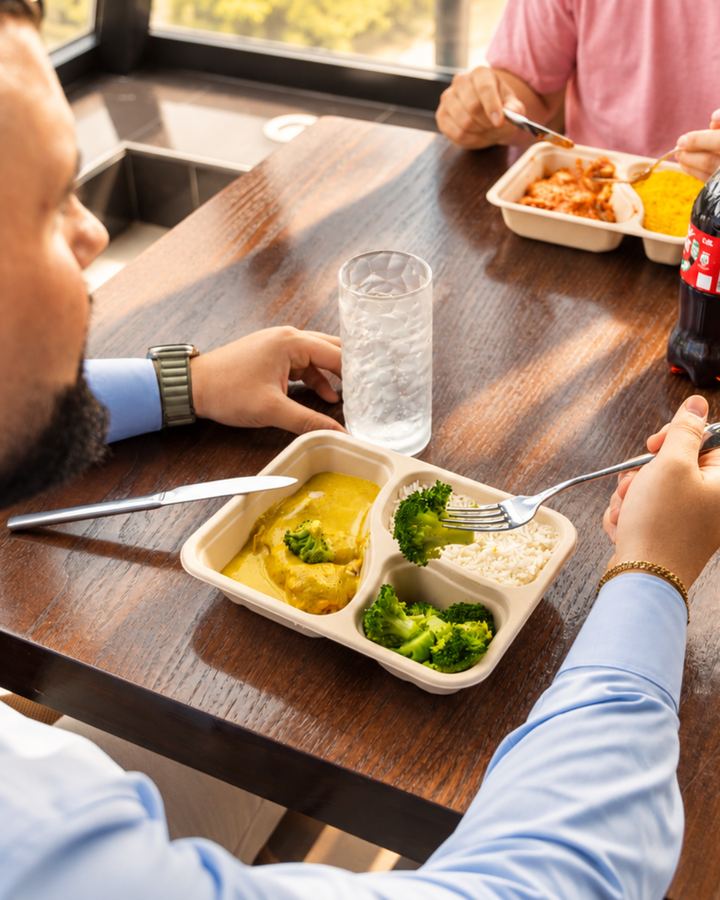 Kollegen essen Mr.-Lunch-Gerichte am gemeinsamen Tisch